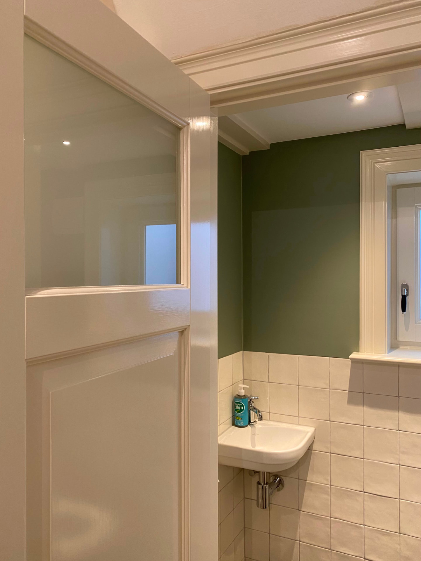 Badkamer met groene wand en strak gelakte kozijnen